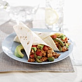 Two Chicken Fajitas with Avocado on a Blue Plate