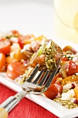 Heirloom Tomato Salad with Pesto Sauce; Fork Stabbing Tomato