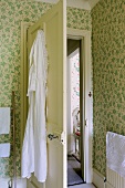 Alte Motivtapete und historische Tür im Badezimmer eines englischen Landhauses