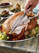 Man Carving a Roasted Turkey on a Rustic Table
