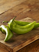 Three Green Jalapeno Peppers on Cutting Board