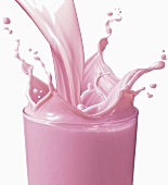 Strawberry Milk Pouring into a Glass; Splashing