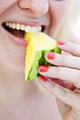 A woman eating a yellow watermelon