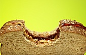 Peanut Butter and Jelly Sandwich on Wheat Bread with Bite Taken Out