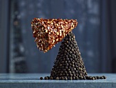 Red Pepper Flakes and Black Peppercorns in the Form of Cones