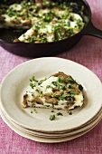 Slice of Mushroom Frittata on Stacked White Plates; Frittata in a Skillet