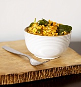 Bowl of Spiced Pumpkin Risotto with Raisins and Spinach; Fork