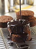Chocolate Sauce Pouring Over Round Brownies on a Cooling Rack
