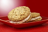 Two Oatmeal Whoopie Pies on a Red Plate