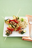 Grilled Sausage and Veggie Kabobs with Brown Rice on a White Plate