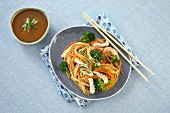 Sesame Chicken and Broccoli Over Asian Noodles; Chopsticks