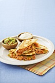 Salmon and Cheese Quesadillas on a Plate with Sour Cream and Guacamole