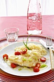 Cod with Cherry Tomatoes and Rice on a Plate; Knife and Fork