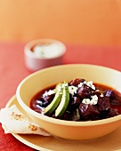 Bowl of Beef Chili with Avocado and a Tortilla
