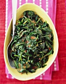 Wilted Greens with a Spicy Peanut Sauce in a Serving Bowl; From Above