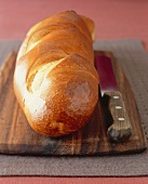 Loaf of French Bread on a Cutting Board with a Knife