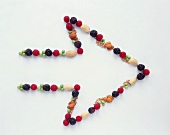 An Arrow on a White Background Formed with Fruits and Nuts