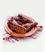 Barbecued Chicken Legs on an Orange Plate