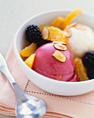 Scoops of Sorbet in a Bowl with Fresh Fruit and Sliced Almonds; Spoon