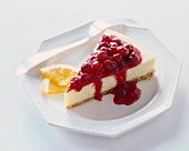 Slice of Cheesecake with Cherry Sauce Topping; On a White Plate