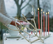 A branch decorated with glass pendants and candles