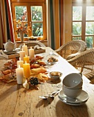 A wooden table with autumnal decoration and crockery