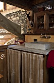 A stone wash basin in the kitchen corner of a rustic house