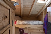 Eingebautes Bett unter dem Dach eines holzvertäfeltem Zimmer