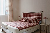 Doppelbett mit zwei Matratzen & mit rot-weiss kariertem Kopfteil, Tagesdecke & Kissen