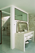Gemauerter Waschtisch mit zwei Waschbecken & Spiegel in Badezimmer mit Glasfenster zum Flur