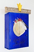 A blue, hand-painted wall cabinet