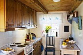 A kitchen in country house with wooden cupboard and a wooden ceiling