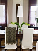 Elegantes Esszimmer - Stühle mit Hussen am Holztisch und weisser Lampenschirm