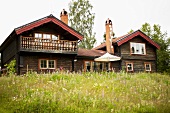 Two wooden houses with gable roofs in a field