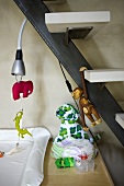 Toys and reading lamp handing under a staircase