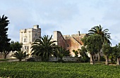 Romanische Burg in Italien mit Palmen in Gartenanlage