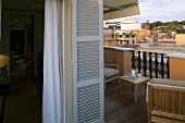 Gemütliche Stimmung auf Dachterrasse mit Blick auf südländische Stadt