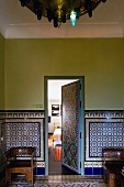 Marokkanischer Vorraum mit blau gemusterten Fliesen und offenstehender Tür