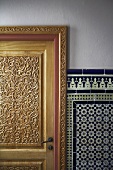 Carved wooden door and white and blue oriental wall tiles