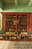 Bücherschrank aus Mahagoni vor grüner Wand