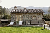 Renovated stone building with elegant patio furniture and a well manicured lawn