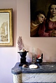 Still life - decorative objects on a stone mantelpiece in front of a pink wall