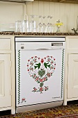 A dishwasher with a heart and animal motif being filled up