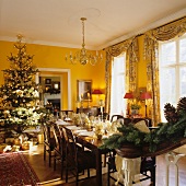 A Christmas party in a dining room of an English country-house with floor-to-ceiling windows and yellow walls