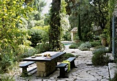 An idyllic terrace with a natural stone floor in a Mediterranean garden