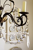 Detail of a candle holder with glass decorations and a dresser with plates