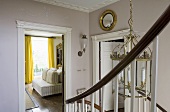 An elegant stairway with an open door and view into the living room