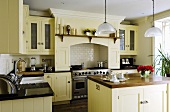 A light yellow kitchen in an English country house with an island counter