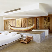 A Mediterranean bedroom with a boat displayed on a concrete pedestal