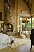 A natural stone fireplace in a bedroom in a South African house